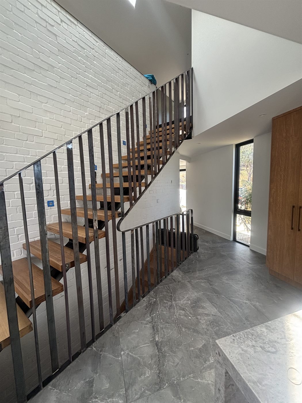 Flat-bar steel balustrade to timber-tread staircase